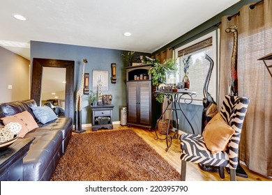 Beautiful Tropical Theme Interior With Exotic Animal Statues, Brown Soft Rug, Leather Couch And Zebra Print Chair