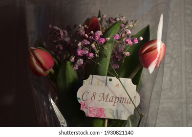 Beautiful tulips on a white background with a sign on March 8.