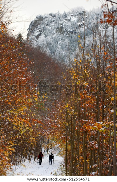 Beautiful turn of autumn and\
winter. Nice autumn weather with first powder snow and two people\
going for a walk. Jizerske mountains (Giant mountains), Czech\
Republic.