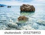 The beautiful turquoise waters and small rock outcrops of the east end of Jaz Beach which is one of the longest in the Budva, Montenegro area.