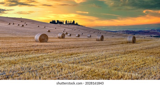 Beautiful Tuscany landscape with traditional farm house and hay bales in golden evening light, Val d'Orcia, Italy.