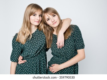 Beautiful two twins sisters together holding each other in hugs