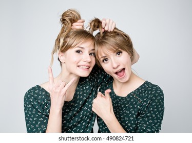 Beautiful two twins sisters together with funny hairstyle. Close-up beauty portrait
