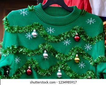 Beautiful or ugly: green Christmas sweater with decor balls  - Shutterstock ID 1234985917