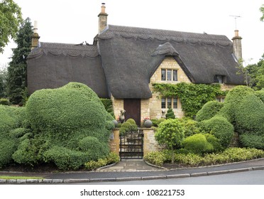 Beautiful Upper Class Cottage With Thatched Roof And Funny Cut Hedges In The Village Of Chipping Campden, Cotswold, United Kingdom.