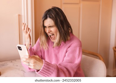 Beautiful upset woman sitting alone near big window in coffee shop, relaxing in restaurant during free time. Sad angry female having talking conversation with mobile phone, yelling. Screaming woman. - Powered by Shutterstock