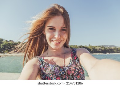 Beautiful urban woman taking picture of herself, selfie. Filtered image.