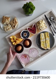 A Beautiful Varied Breakfast In The Assortment On A Tray. A Young Girl Makes A Beautiful Serving And Delicious Buns With Fruits