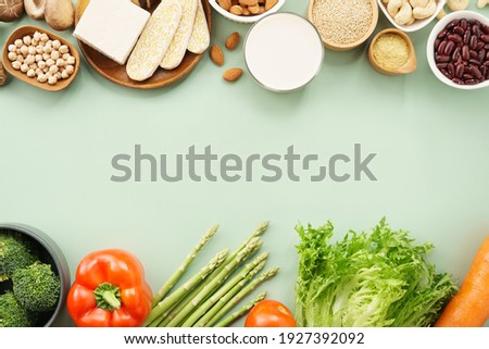 Beautiful of variety vegetables and healthy plant protein arranging in horizontal with space on green background. Balanced healthy and happy Vegan, Alternative protein, less meat, Dairy-free, Top view