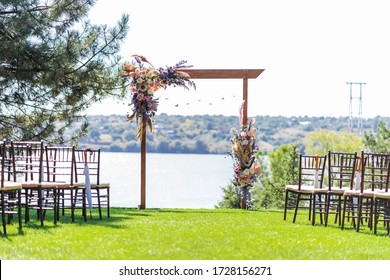 A beautiful venue for an open-air wedding ceremony. Wedding arch and rows of guest chairs on a green lawn overlooking the river.