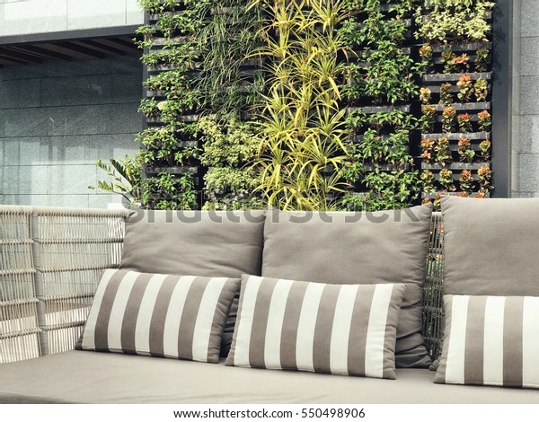 Beautiful vertical garden with outdoor sofa for\
family relaxing zone