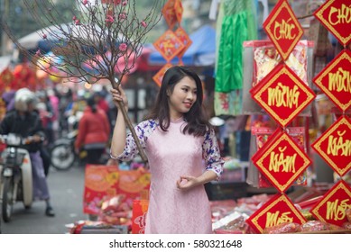 Beautiful Vietnamese girl with traditional dress (ao dai) is on a street in Tet holiday in Hanoi, Vietnam