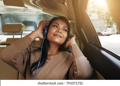 Beautiful Vietnamese Woman Sitting In Car And Listening To Her Favorite Music