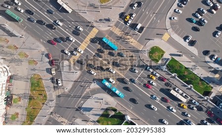 Beautiful view from above to a busy road junction in Moscow. Colorful cars and trucks driving straight forward in both directions and pedestrians crossing the road on a sunny summer day.