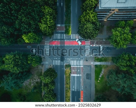 Beautiful view from above to a crossroad in Milan District. Cars crossing busy intersection surrounded by houses.  Drone view of the crossroads at evening time.
