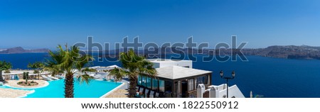 Beautiful view from Akrotiri to caldera and volcano on a sunny day. Panoramic format. Santorini island, Cyclades, Greece, Europe.
