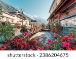 Beautiful view of Chamonix Mont Blanc downtown among the French alps in autumn with flower blooming, canel and architechural classic building at Haute Savoie, France