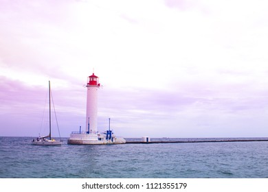 Beautiful view. The current lighthouse. Vorontsov lighthouse in Odessa against the background of the Black Sea, closeup. White tower with a red cabin at the top on a background of blue seascape