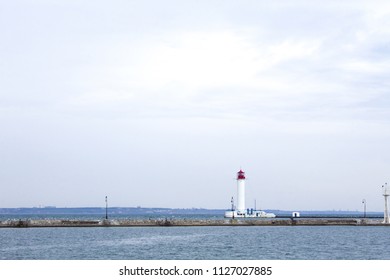 Beautiful view. The current lighthouse. Vorontsov lighthouse in Odessa against the background of the Black Sea, closeup. White tower with a red cabin at the top on a background of blue seascape