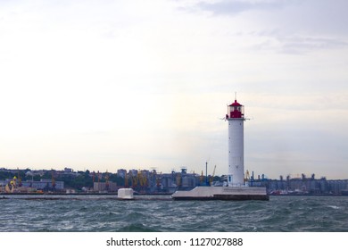 Beautiful view. The current lighthouse. Vorontsov lighthouse in Odessa against the background of the Black Sea, closeup. White tower with a red cabin at the top on a background of blue seascape