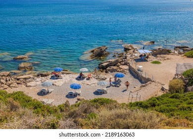 Beautiful View Of Endless Blue Sea Water Surface And Rear Sun Beds With People On Beach. Greece. Rhodes. 