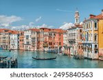 Beautiful view of the Grand Canal with boats and colorful facades of old medieval houses from the Rialto Bridge in Venice, Italy. Venice is a popular tourist destination of Europe.