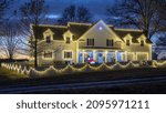 A beautiful view of a great house with lights decoration and trees in the background at night