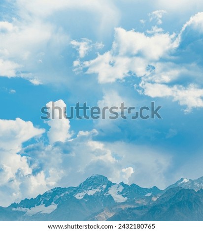 beautiful view of head of mountain covered with snow and blue stormy sky with white clouds