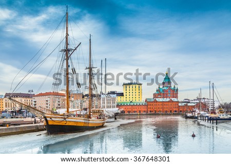 Beautiful view of Helsinki city center with famous Uspenski eastern orthodox cathedral church and old port in Katajanokka district of Helsinki on a cold winter day with blue sky and clouds, Finland