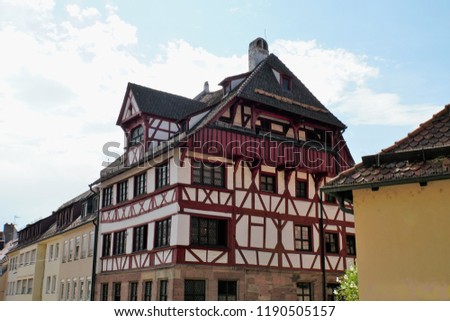 Beautiful View Of Historical Nuremberg City At Sunny Day. Historic Highlights of Germany. Nuremberg is the birthplace of Albrecht Duerer and Johann Pachelbel. Red-Brown And White Background. 