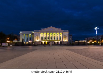 Beautiful view of the illuminated building of the Tyumen Big Drama Theater and the Square of the 400th Anniversary of Tyumen at twilight, Russia