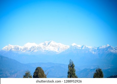 Beautiful view of Kanchenjunga mountain range and daylight on it. View from Batasia Loop Darjeeling in a clear blue sky and sunny weather during winter season, a popular India travel destination scene - Powered by Shutterstock