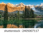 Beautiful view of Lac des Gaillands with train passing and Mont Blanc massif reflection in the sunset at Chamonix, Haute Savoie, France