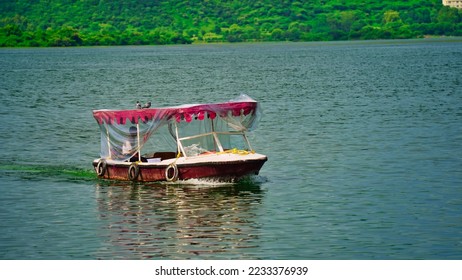Beautiful view of Lake Palace. Tourists boat riding in lake. India. Jag Niwas in Lake Pichola for the royal dynasty of Mewar. Cityscape, Udaipur tourism