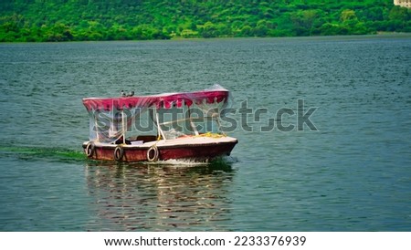 Beautiful view of Lake Palace. Tourists boat riding in lake. India. Jag Niwas in Lake Pichola for the royal dynasty of Mewar. Cityscape, Udaipur tourism