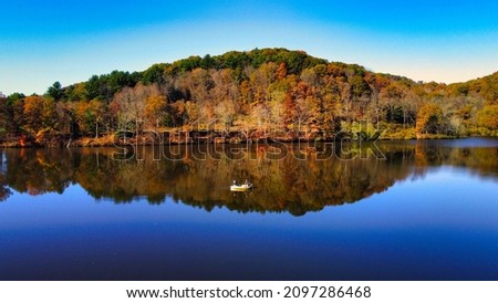 A beautiful view of a lake surrounded by autumn trees in Pittsburgh, PA