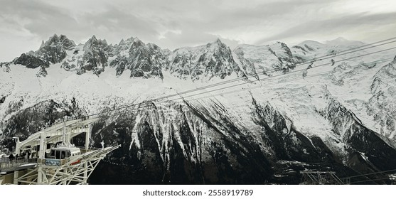 Beautiful view from Le Brevent over Mont Blanc massif and Chamonix valley with cable car and ski lift with snow capped mountains and dark forest, with few people on platform
 - Powered by Shutterstock