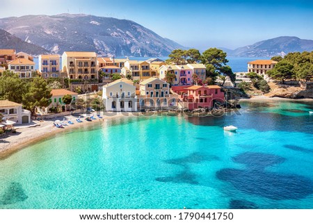 Beautiful view to the little beach of the village Assos, Kefalonia, Greece, with turquoise sea and colorful houses directly on the shore