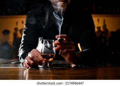 Beautiful View Of Male Hands Holding A Glass Of Strong Alcoholic Drink And Smoking Cuban Cigar