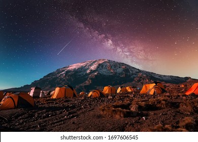 Beautiful view of the milky way over mount Kilimanjaro, Tanzania with many tents at the base camp. Millions of stars in the night African sky.