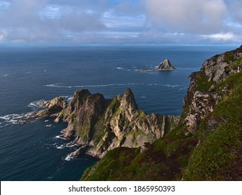 Beautiful view of the northwestern coast of Andøya island, Vesterålen, Norway with rugged mountains and cliffs as well as popular bird rock Bleiksøya in the Norwegian Sea on sunny summer day.