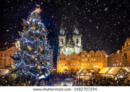 Beautiful view to the old town square of Prague during night time with a Christmas market in winter time with snow falling, Czech Republic