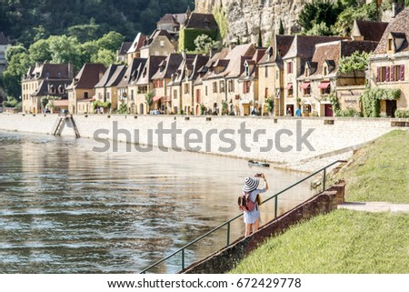 Beautiful view on the famous La Roque Gageac village with tourist standing near the river in France