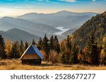 Beautiful view on small wooden cabin and Zaovine lake before sunset in autumn at viewpoint Zmajevac, Tara mountain, Serbia.