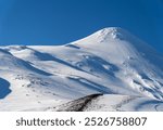 A beautiful view of the Osorno Volcano Ski Resort in Puerto Varas, Chile, on a sunny winter day, with clear skies and snow-covered slopes.