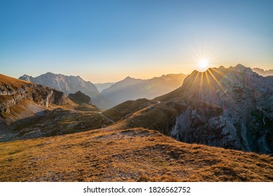 beautiful view over the Julian Alps with the sun setting over a beautiful mountain ridge on a sunny day in autumn. Enjoying beautiful mountain vistas with a sun star while traveling in Europe.  - Shutterstock ID 1826562752