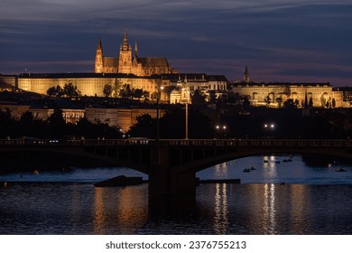 A beautiful view Prague Castle in night near a bridge over river