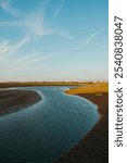 Beautiful view of a river flowing in Gaomei Wetlands in Taichung during sunset in the evening with blue sky