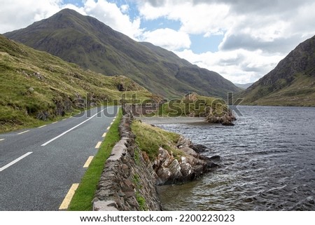 Beautiful view of Road R335 on the side of Doo Lough, in County Mayo, Ireland. Ben Gorm mountain on the background