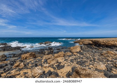 Beautiful view of the rocky coastline of Aruba with clear blue skies and turquoise waters. - Powered by Shutterstock